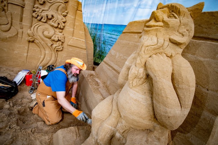 Ein Mann schnitzt eine Sandfigur - Copyright: Bastian Modrow